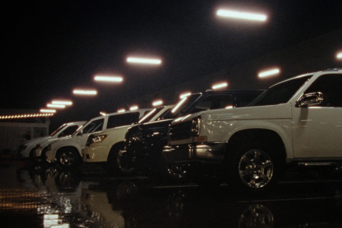 A row of clean fleet vehicles in a professional shop at night